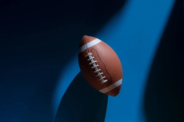 青い背景に自然光のアメリカのサッカーボール 水平スポーツのテーマのポスター グリーティングカード ヘッダー ウェブサイトとアプリ — ストック写真