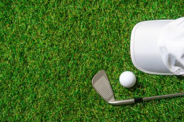 Beyaz golf topu, kep ve yeşil çimlerin üzerinde sopa. Yatay spor posteri, tebrik kartları, başlıklar, web sitesi