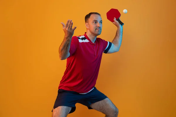 Man plays table tennis on yellow studio background. Professional player plays ping pong. Horizontal sport theme poster, greeting cards, headers, website and app
