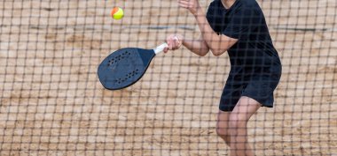 Kumsalda tenis oynayan bir adam. Yatay spor posteri, tebrik kartları, başlıklar, web sitesi