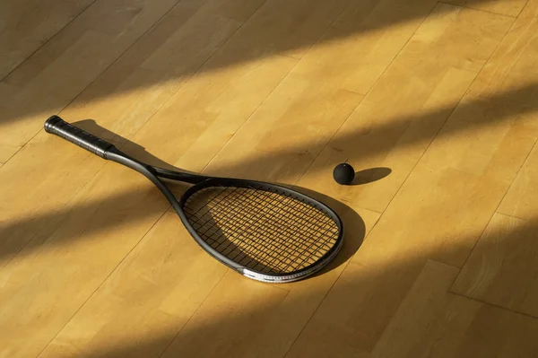 Svart Squash Racket Och Boll Med Naturlig Belysning Grå Bana — Stockfoto
