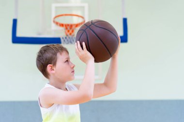 Beden eğitimi dersinde basketbol oynayan okul çocuğu. Yatay eğitim posteri, tebrik kartları, başlıklar, web sitesi