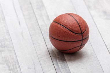 Beyaz ahşap kortta basketbol topu. Yatay spor temalı poster, tebrik kartları, başlıklar, web sitesi ve uygulama