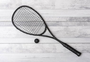 Gri sahada siyah squash raketi ve top. Yatay spor temalı poster, tebrik kartları, başlıklar, web sitesi ve uygulama