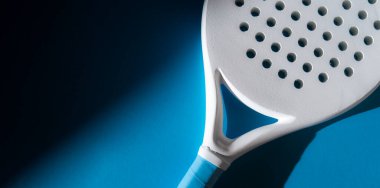 Mavi arka planda doğal ışıklandırması olan beyaz profesyonel raket. Yatay spor temalı poster, tebrik kartları, başlıklar, web sitesi ve uygulama