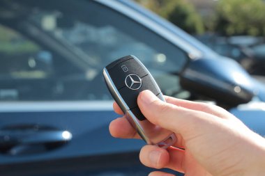 Arka planda arabası olan Mercedes-Benz araba anahtarı.