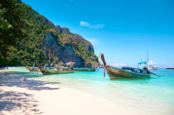 Phi Phi Adaları 'nda güneşli bir günde Tayland' da bir turist teknesiyle plaj ve okyanus manzarası.