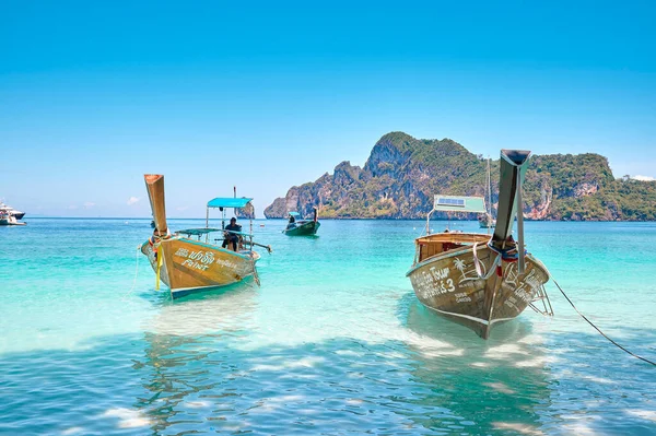 Phi Phi Adaları 'nda güneşli bir günde Tayland' da bir turist teknesiyle plaj ve okyanus manzarası.