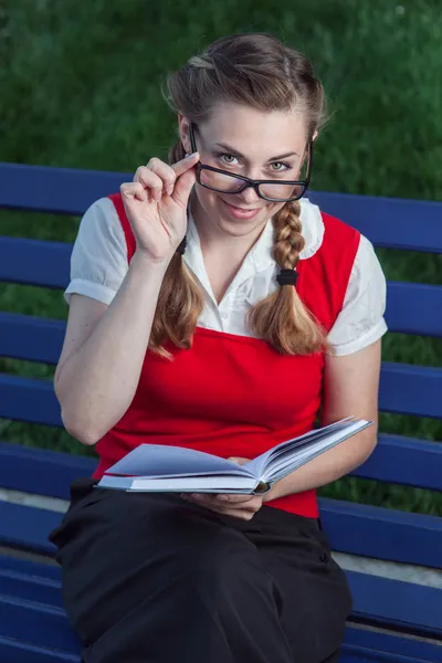 Menina estudante no parque com flores — Fotografia de Stock