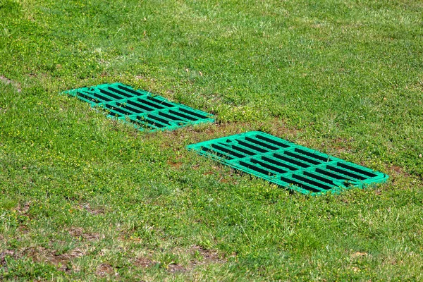 芝草浄化槽カバー付き芝生の上の流域格子排水をキャッチ 2つの長方形の緑のエコハッチは 排水システム環境デザイン — ストック写真