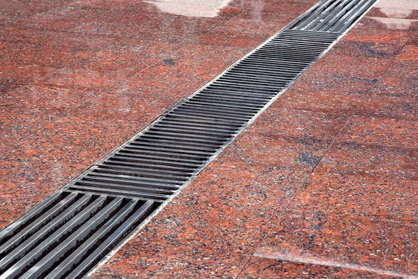 Drainage Grate Stripes Floor Wet Red Stone Granite Surface Close — Stock Photo, Image