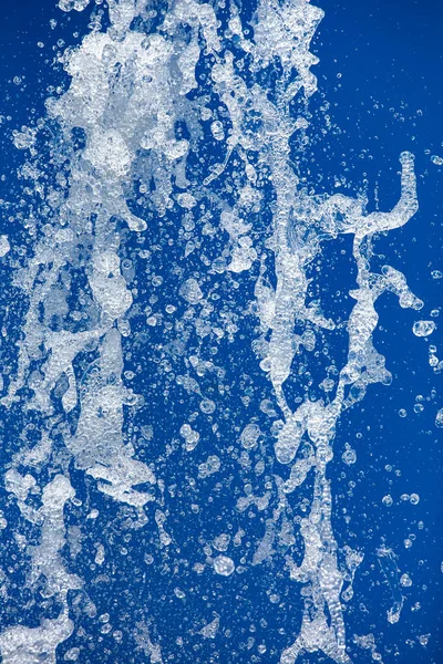 Strumień Wody Rozpylany Pod Ciśnieniem Fontanny Niebieskim Tle Zamrożone Ruchy — Zdjęcie stockowe