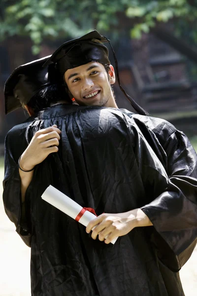 College graduates hugging — Stock Photo, Image