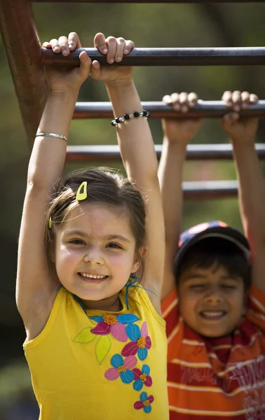 Enfants suspendus sur des barres de singe — Photo