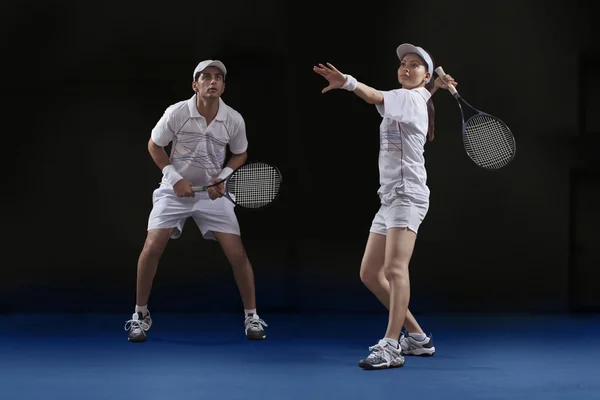 Mannelijke en vrouwelijke spelers tennissen — Stockfoto