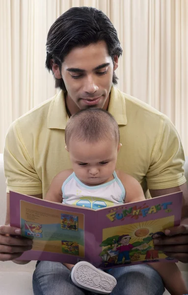 Pai e filho lendo um livro — Fotografia de Stock