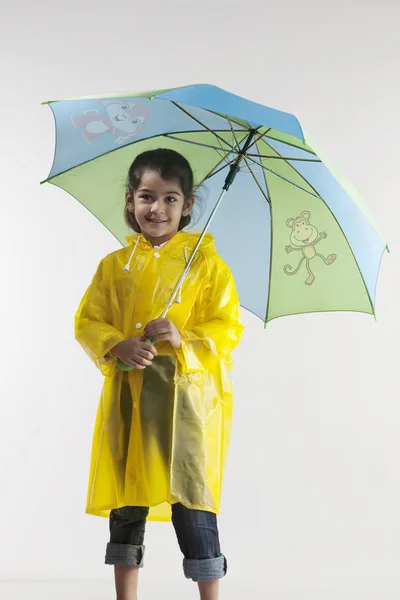 Girl wearing a raincoat and holding an umbrella — Stock Photo, Image