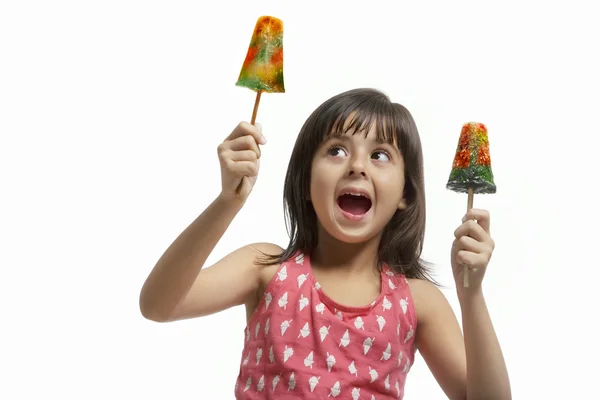 Liten flicka håller två ice lollies — Stockfoto