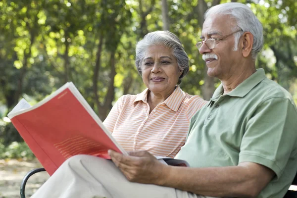 Old couple reading in park