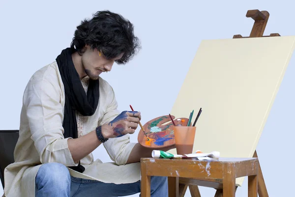 Mladý muž umělec maluje — Stock fotografie