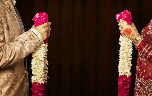 Indiase bruid en bruidegom houden slingers — Stockfoto