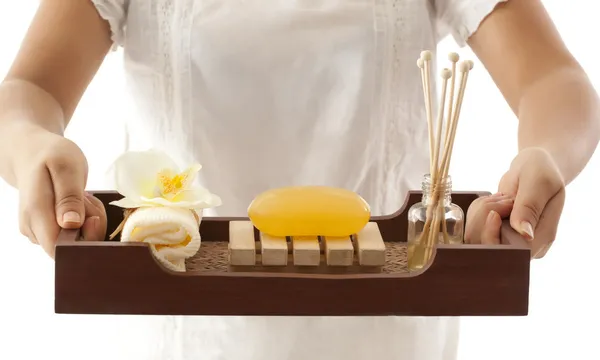 Mãos segurando uma bandeja com produtos de banho — Fotografia de Stock