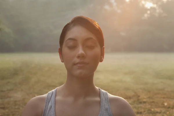 Mujer meditando en el césped — Foto de Stock