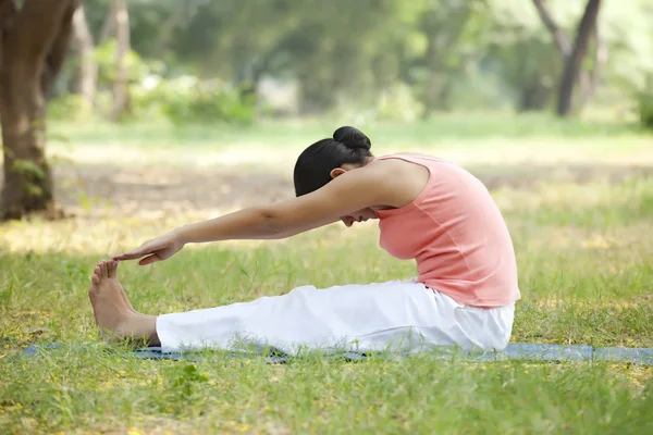 Mujer haciendo yoga en el césped — Foto de Stock