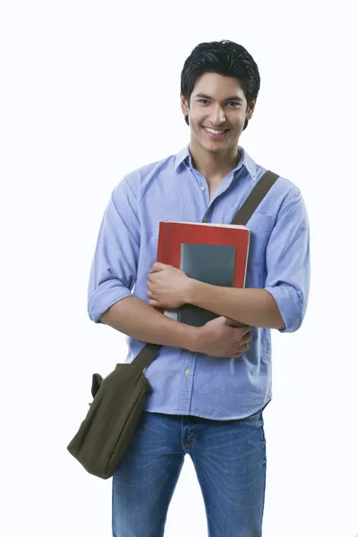 Junger Mann mit Büchern und Umhängetasche — Stockfoto