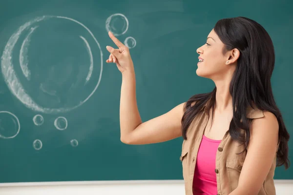 Mujer universitaria soplando la burbuja — Foto de Stock