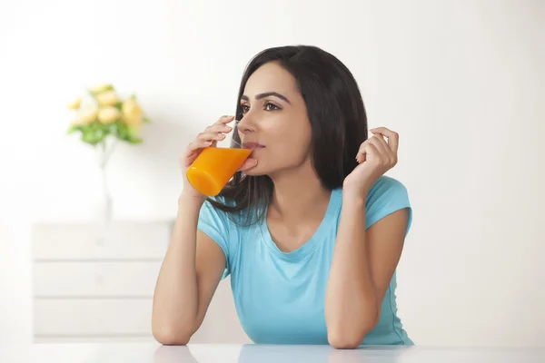 Jeune femme avec un verre de jus d'orange — Photo