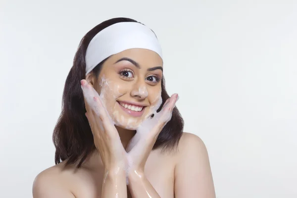 Mujer sonriente lavando la cara — Foto de Stock