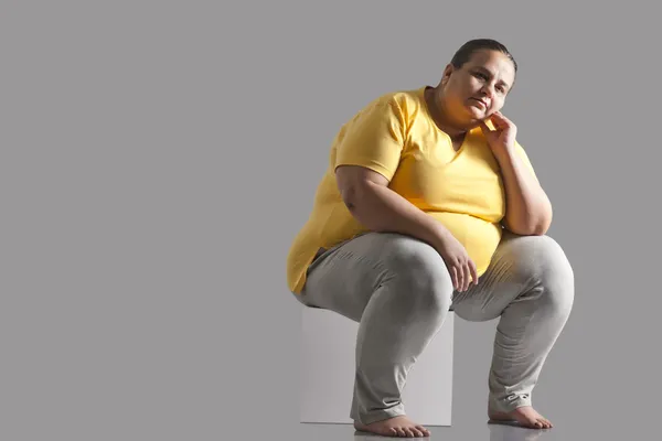 Retrato de una mujer obesa sentada — Foto de Stock