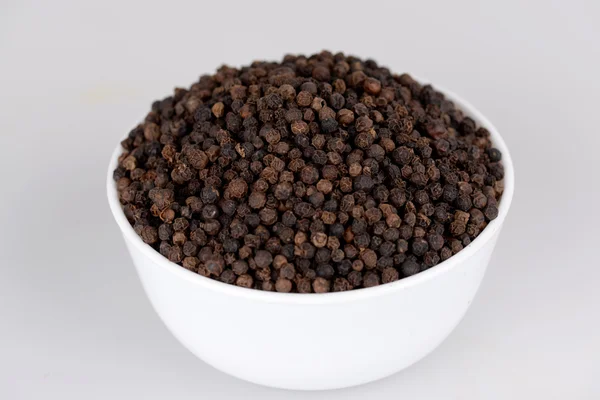 Black pepper in white bowl with white bacground — Stock Photo, Image