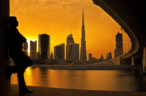 Man kijken zonsondergang achter's werelds hoogste toren burj khalifa in dubai — Stockfoto