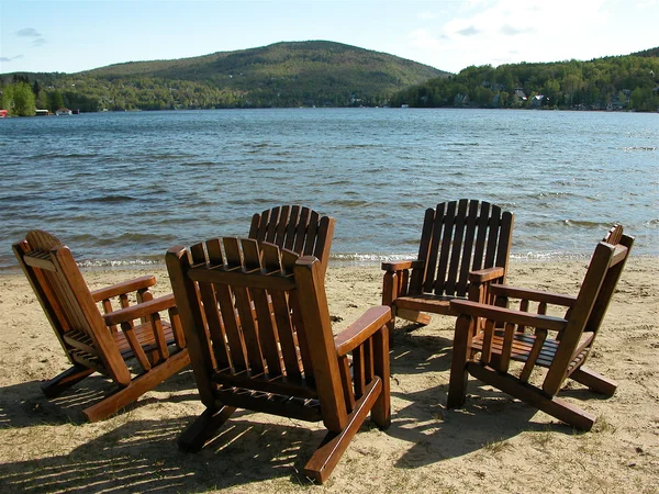 Adirondack stoelen op het meer Stockfoto