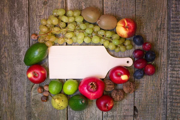 Deska do krojenia pusty na drewniane tła z owocami. — Zdjęcie stockowe