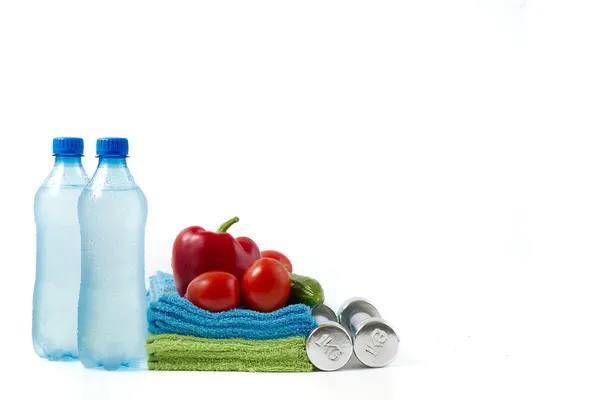 Manubrio fitness con verdure e acqua su sfondo bianco . — Foto Stock