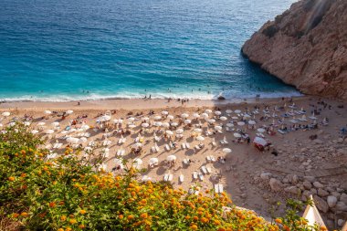 İnsanlar Kumsalda Rahatlıyor. Denizde yüzen insanlar. Kas ve Kalkan arasındaki Kaputas Sahili 'nin üst manzarası. Türkiye 'nin turkuaz suları, Akdeniz' deki en iyi plajı.