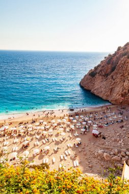 Kas, Turkey - 08. - 25. 2021: İnsanlar Sahilde Dinleniyor. Denizde yüzen insanlar. Kas ve Kalkan arasındaki Kaputas Sahili 'nin üst manzarası. Türkiye 'nin turkuaz suları, Akdeniz' deki en iyi plajı.
