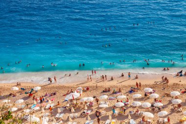 Kas, Turkey - 08. - 25. 2021: İnsanlar Sahilde Dinleniyor. Denizde yüzen insanlar. Kas ve Kalkan arasındaki Kaputas Sahili 'nin üst manzarası. Türkiye 'nin turkuaz suları, Akdeniz' deki en iyi plajı.