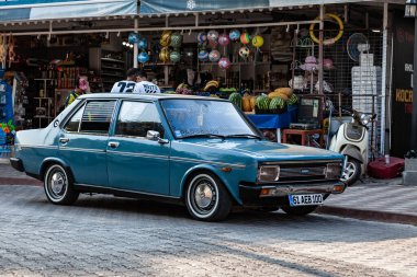 Kemer, Türkiye - 25 Ağustos 2021: Mavi araba Tofas Doğan şehir caddesinde.