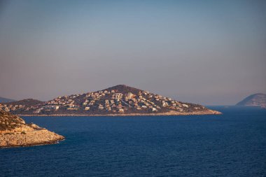 Türkiye 'nin Kas Bölgesi' nde Akdeniz 'in dağlık bir yüzeyinde çok sayıda otel ve eve sahip Cukurbag Yarımadası