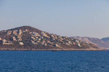 Türkiye 'nin Kas Bölgesi' nde Akdeniz 'in dağlık bir yüzeyinde çok sayıda otel ve eve sahip Cukurbag Yarımadası