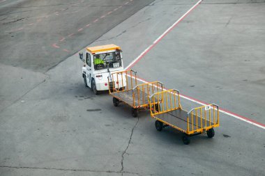 Kemer, Türkiye - 08. - 28. 2021: bir uçak ve havaalanı terminali arasında yolcu taşımak için römorku olan bir traktör. Uçaktan havaalanına bagaj taşımacılığı.