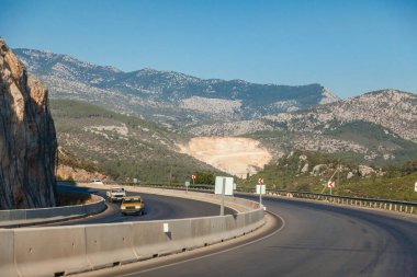 Sıcak bir yaz gününde, dağların ve kayaların arasında hindi otobanı. Turizm ve dinlenme.