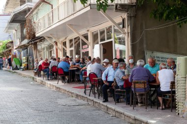 Esilova, Türkiye - 08. - 28. 2021: Emekli yaşlılar küçük bir taşra kasabasında küçük bir sokakta masa oyunu oynuyorlar