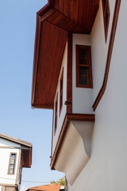 Antalya 'nın eski kasabasında beyaz bina cephesinde balkonlu pencereler, ahşap süsler, hindi - 09. 01 numara. 2021.