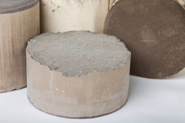 Demir olmayan değerli metallerin geri dönüşümü ve alımı. Beyaz arka planda platin, paladyum ve rodyum içeren kırık seramik katalizörlerin iç kısımlarına yaklaş.