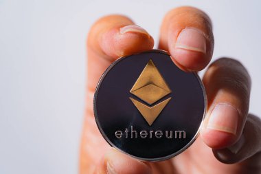 yakın çekim Altın Ethereum ETH dahil olmak üzere Crypto döviz üzerinde mavi takım elbise giyen bir adam. Bana beyaz arkaplan ve boş alan üzerinde metin bir şey koymak için dosyaladı ve koydu ve verdi.